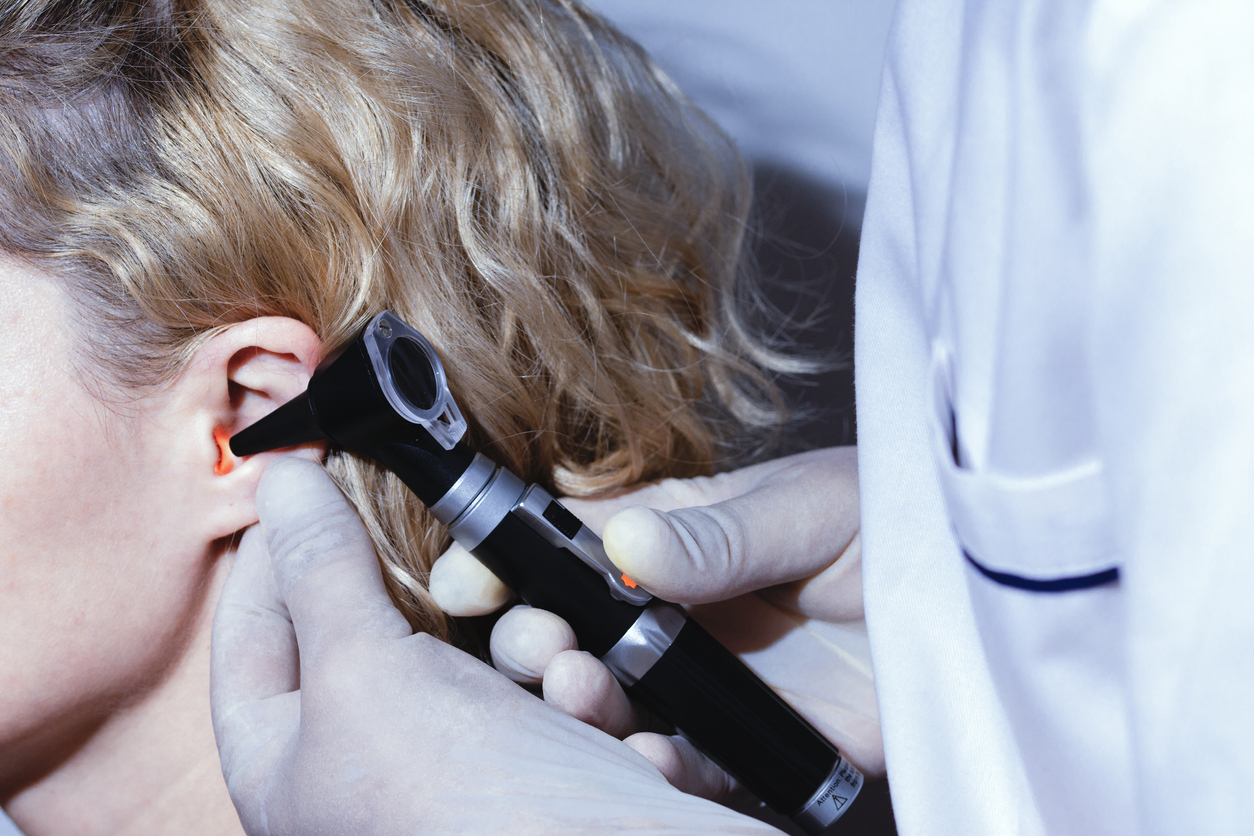 Otologist doctor checking patient ear, ear medical examination